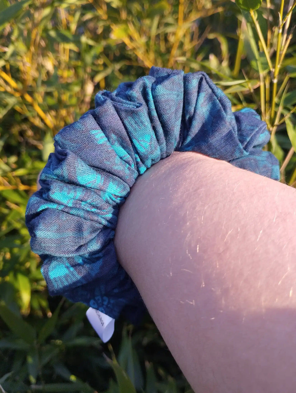 Blue Garden Medium Scrunchie worn on a wrist to show its size
