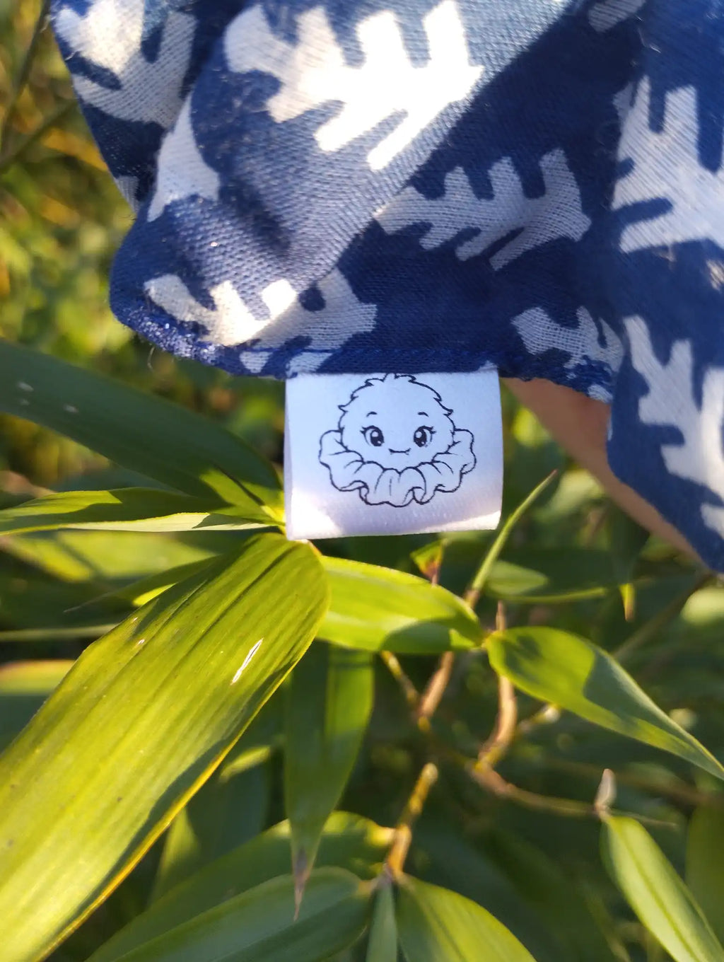 Scrunchlings character label and stitching on Blue Leaf Jumbo Scrunchie