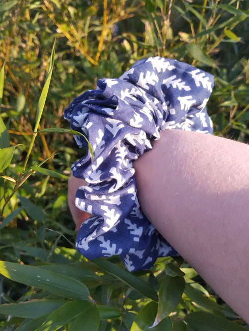 Blue Leaf Jumbo Scrunchie worn on a wrist to show its size