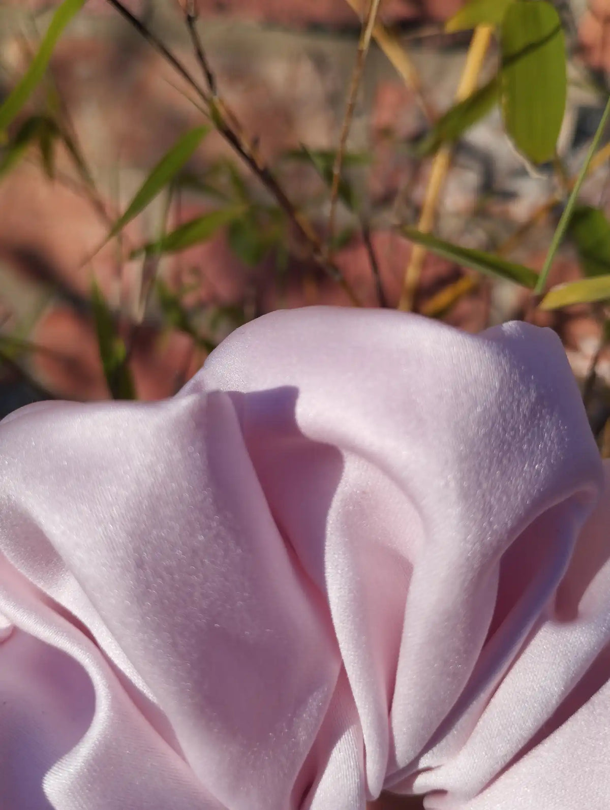 Close-up of the pale blush pink satin fabric and sheen on Blush Pink Jumbo scrunchie