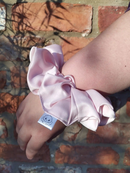 Blush Pink satin Jumbo scrunchie worn on a wrist to show its size
