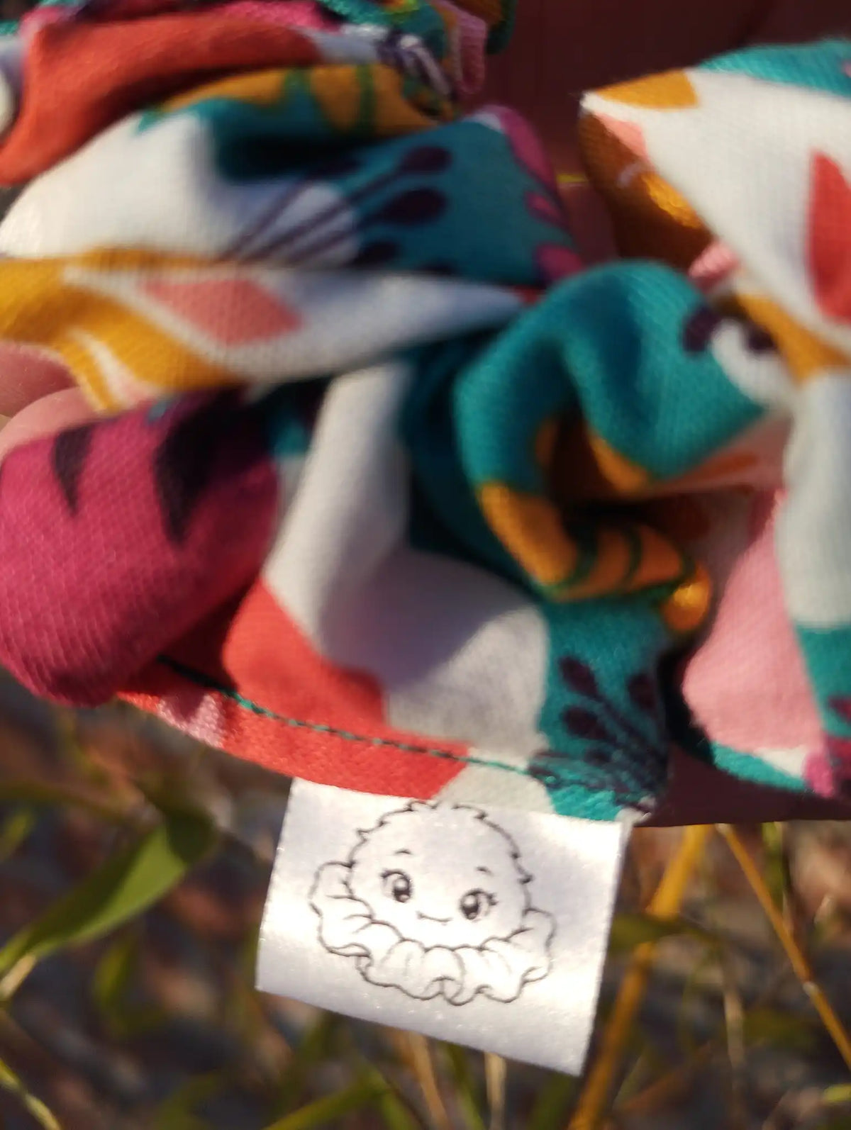 Scrunchlings character label and stitching on Carnival Bloom cotton Medium scrunchie