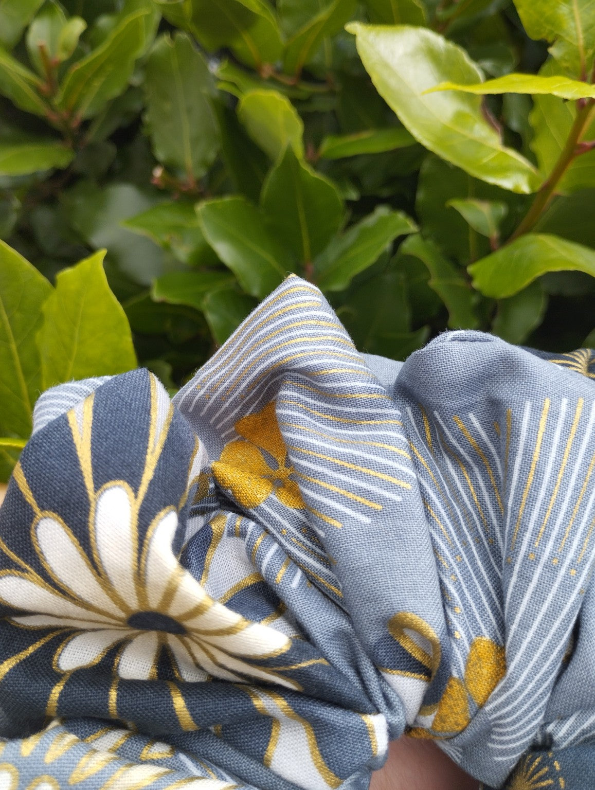 Close-up of the blue-grey, cream and gold floral fabric on Golden Meadow Super Jumbo scrunchie