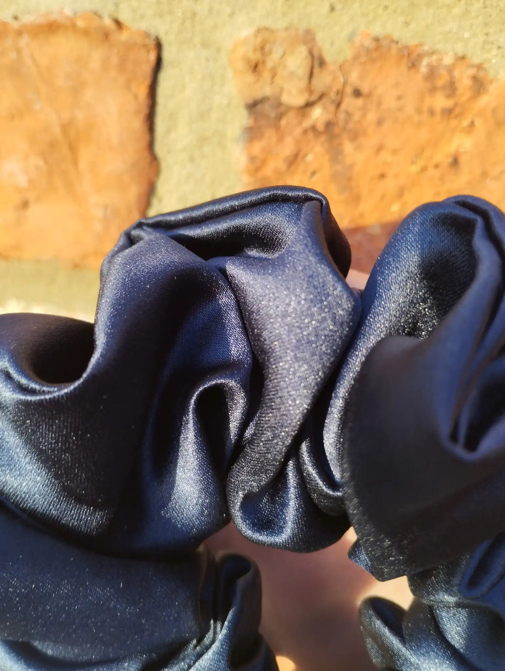 Close-up of the dark navy blue satin fabric and sheen on Inkwell Dark Navy Jumbo scrunchie