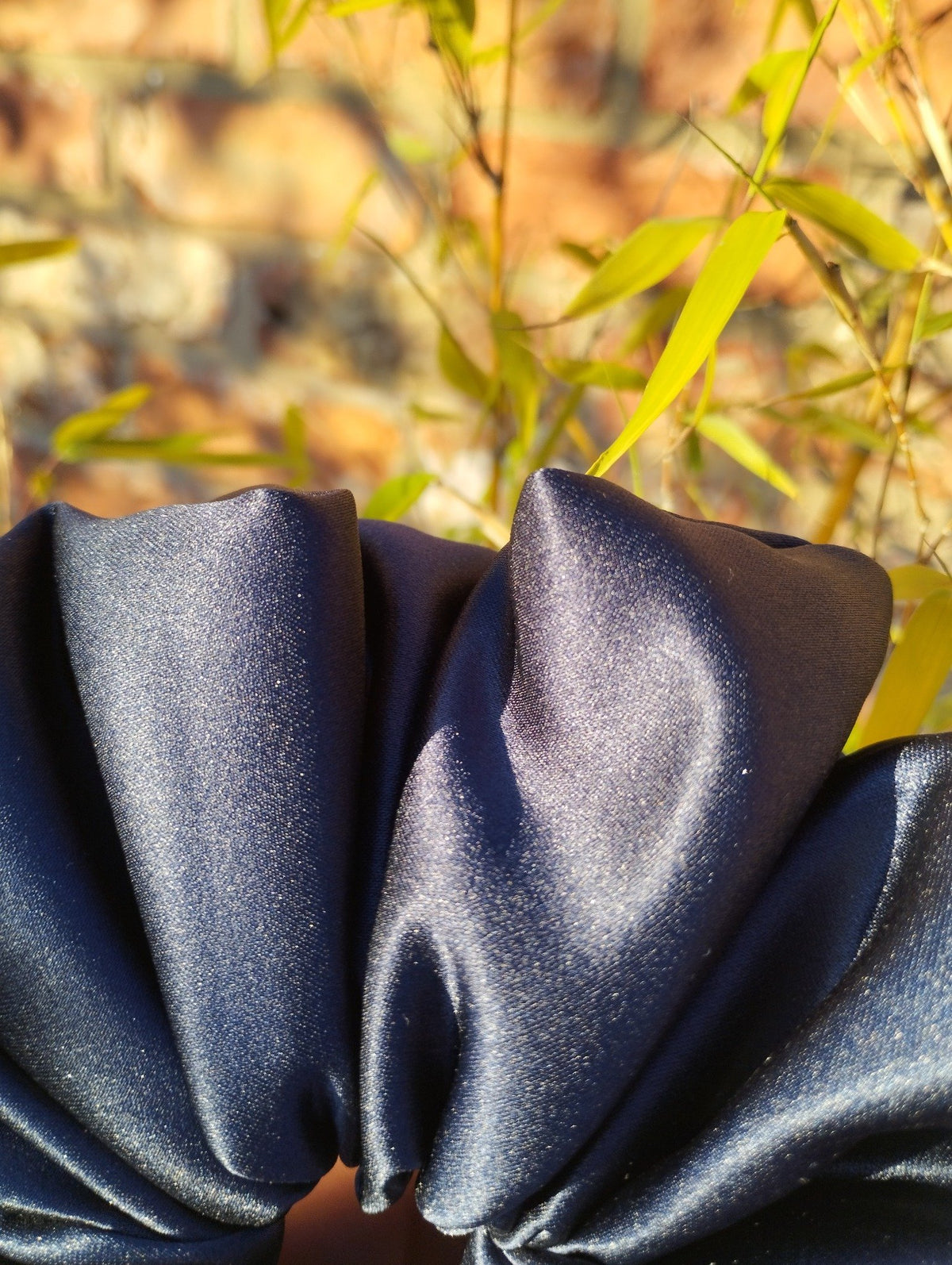 Close-up of the deep navy satin folds and sheen on Midnight Blue Super Jumbo scrunchie