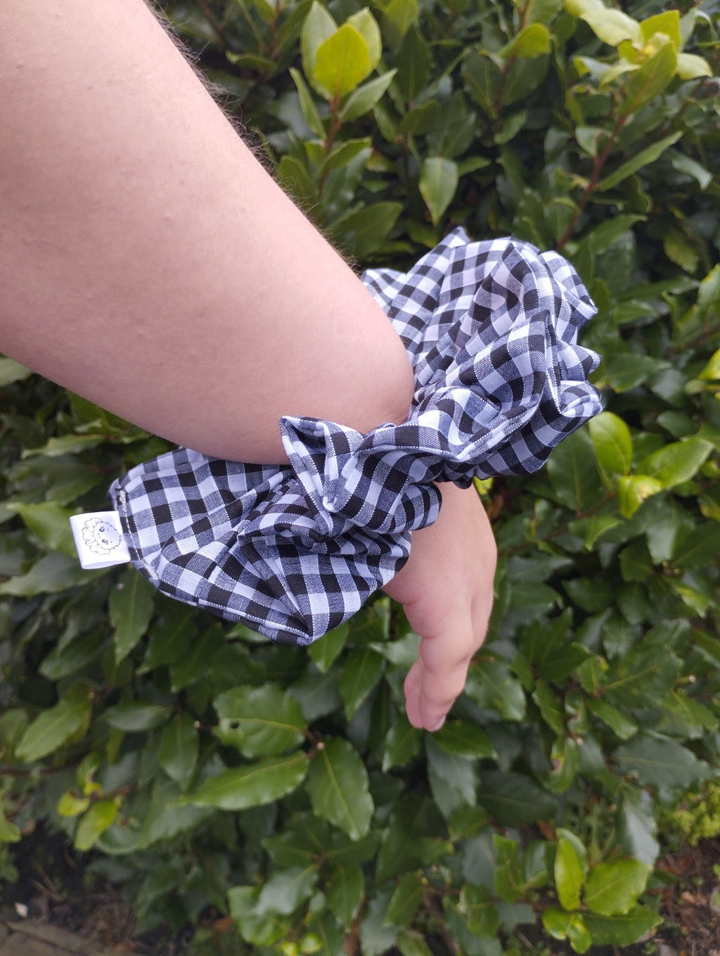 Midnight Gingham oversized black and white checked scrunchie worn on a wrist