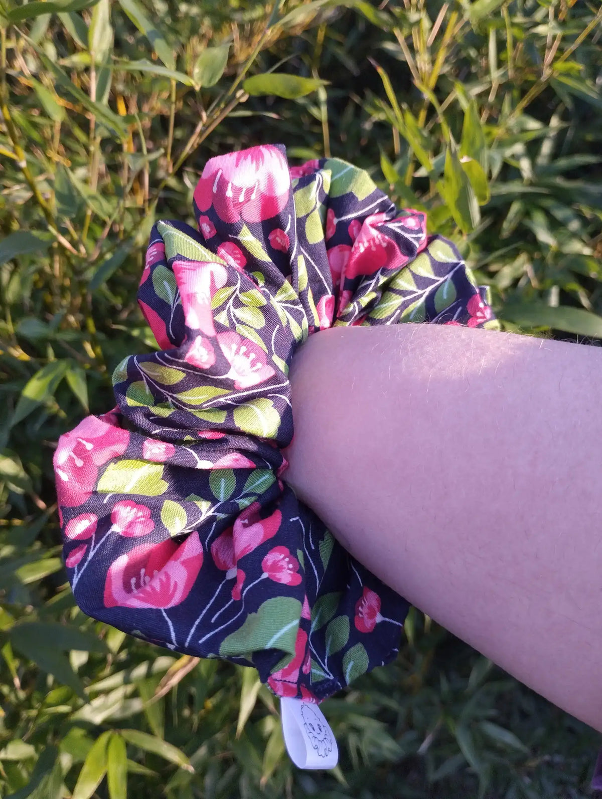 Midnight Poppies Jumbo Scrunchie worn on a wrist to show its size