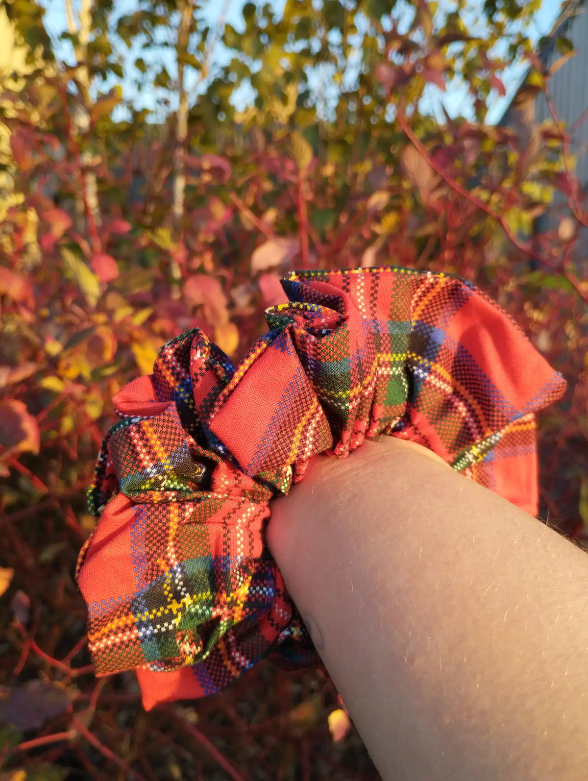 Red Tartan Jumbo Scrunchie worn on a wrist to show its size