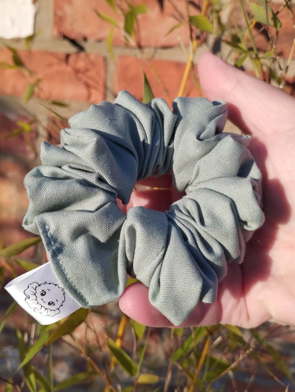 Sage Green cotton Medium scrunchie showing its gathered shape