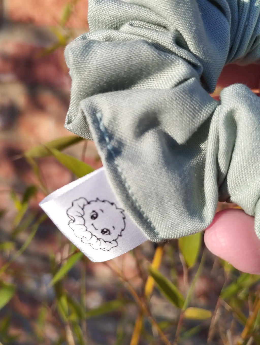 Scrunchlings character label and stitching on Sage Green cotton Medium scrunchie