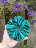 Kingfisher Jade teal jumbo satin scrunchie held in a hand