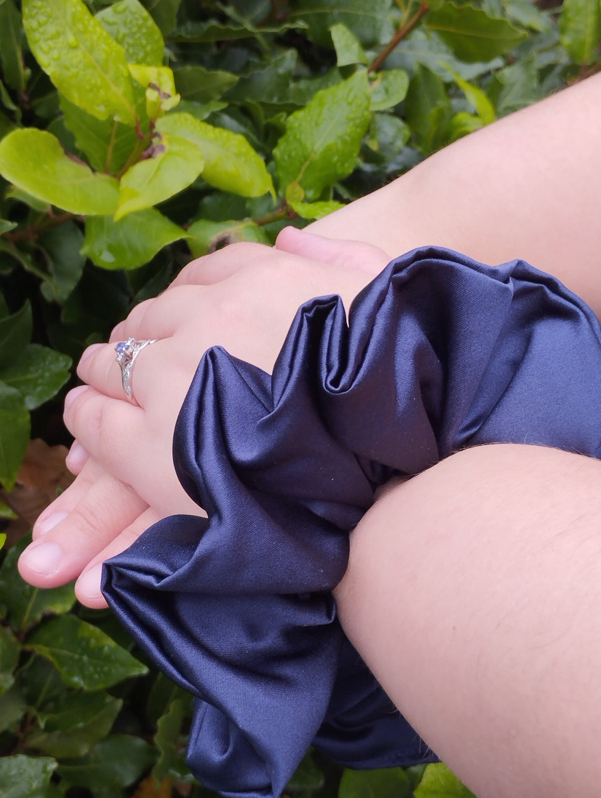Midnight navy blue jumbo satin scrunchie worn on a wrist