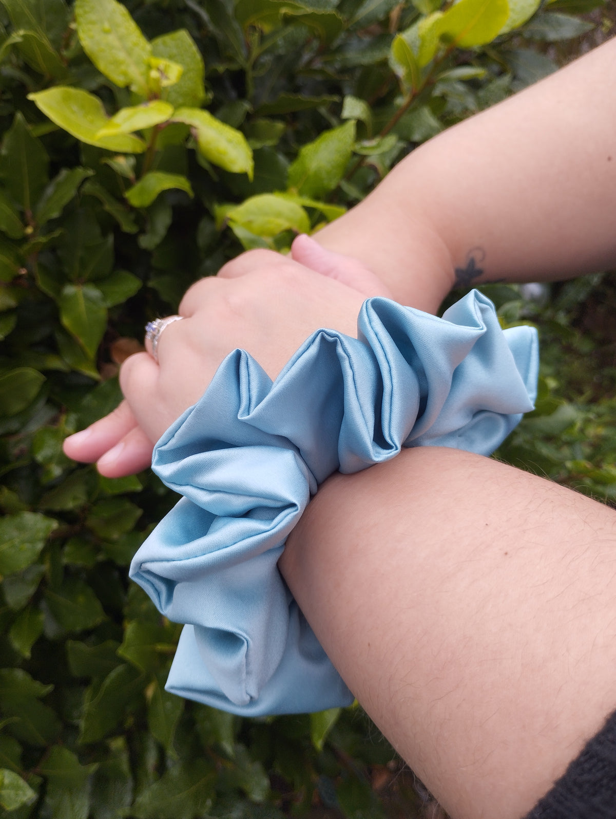 October Sky light blue jumbo satin scrunchie worn on a wrist