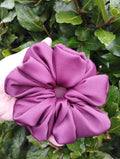 Ruby burgundy jumbo satin scrunchie held in a hand