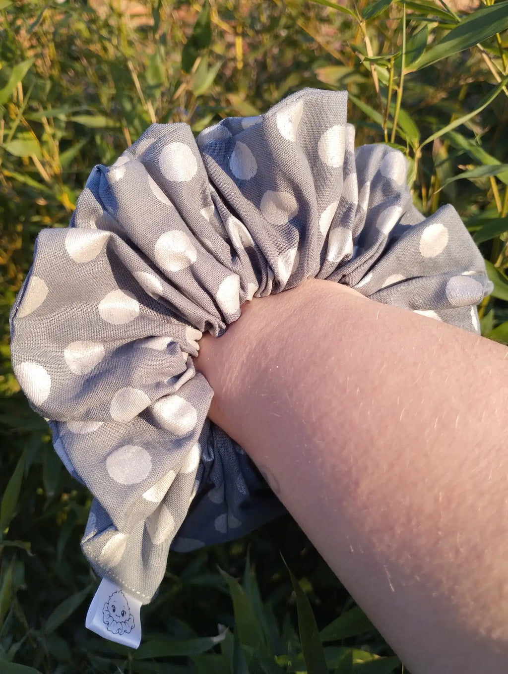 Silver Spot Jumbo Scrunchie worn on a wrist to show its size