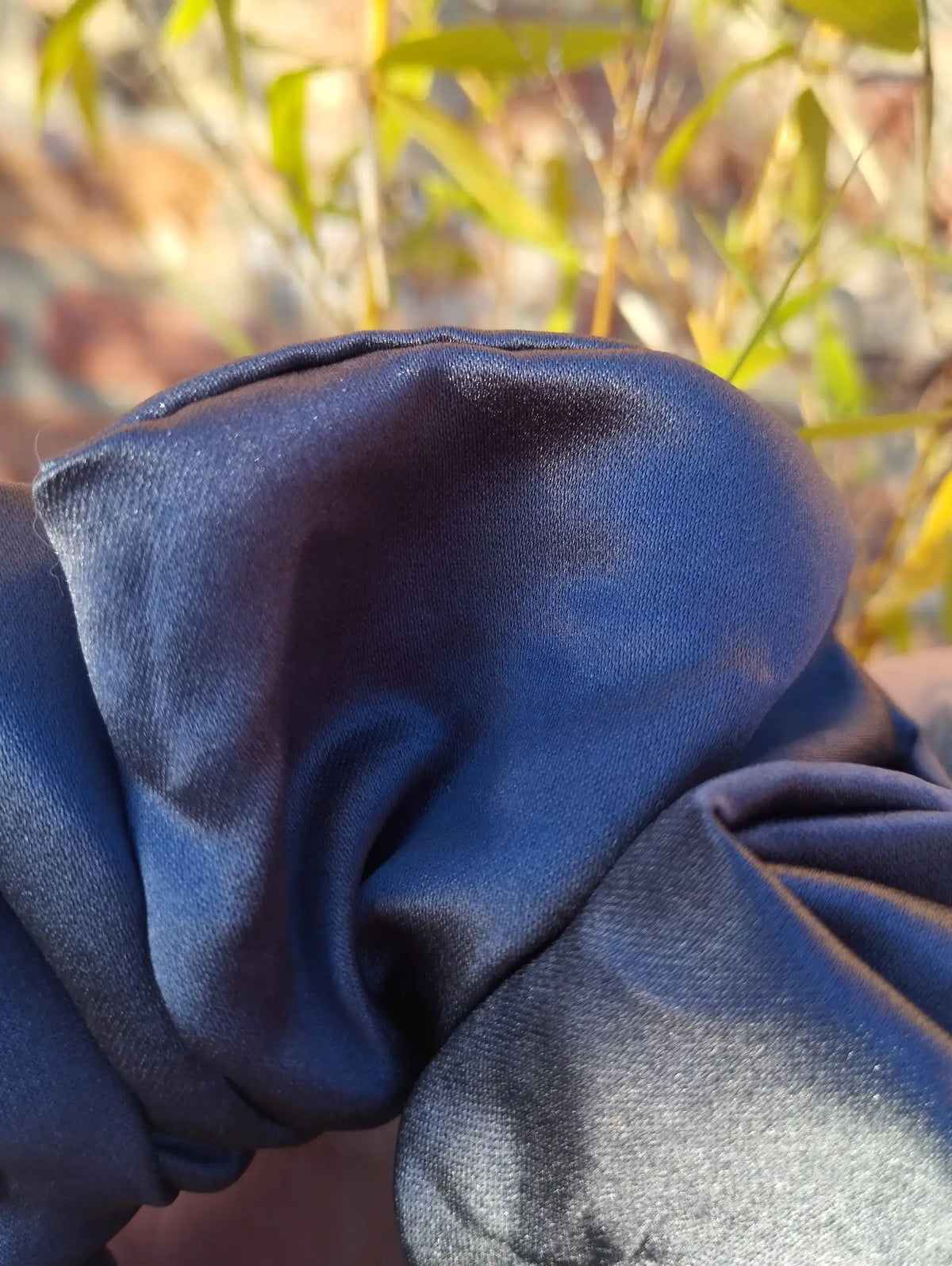 Close-up of the slate grey satin fabric and sheen on Slate Grey Jumbo scrunchie