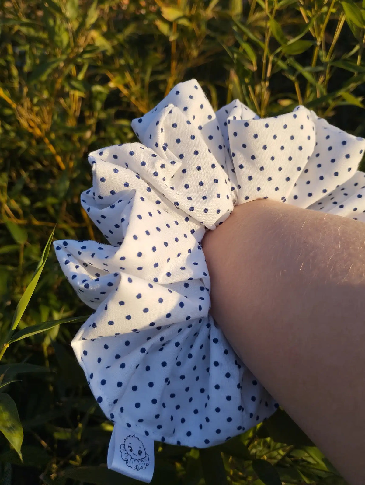 Speckle Dot Jumbo Scrunchie worn on a wrist to show its size