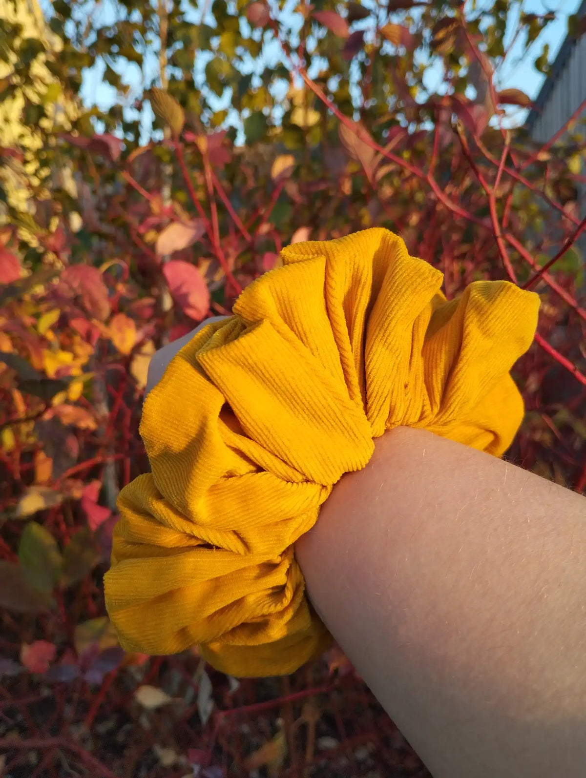 Sunflower Gold Jumbo Scrunchie worn on a wrist to show its size