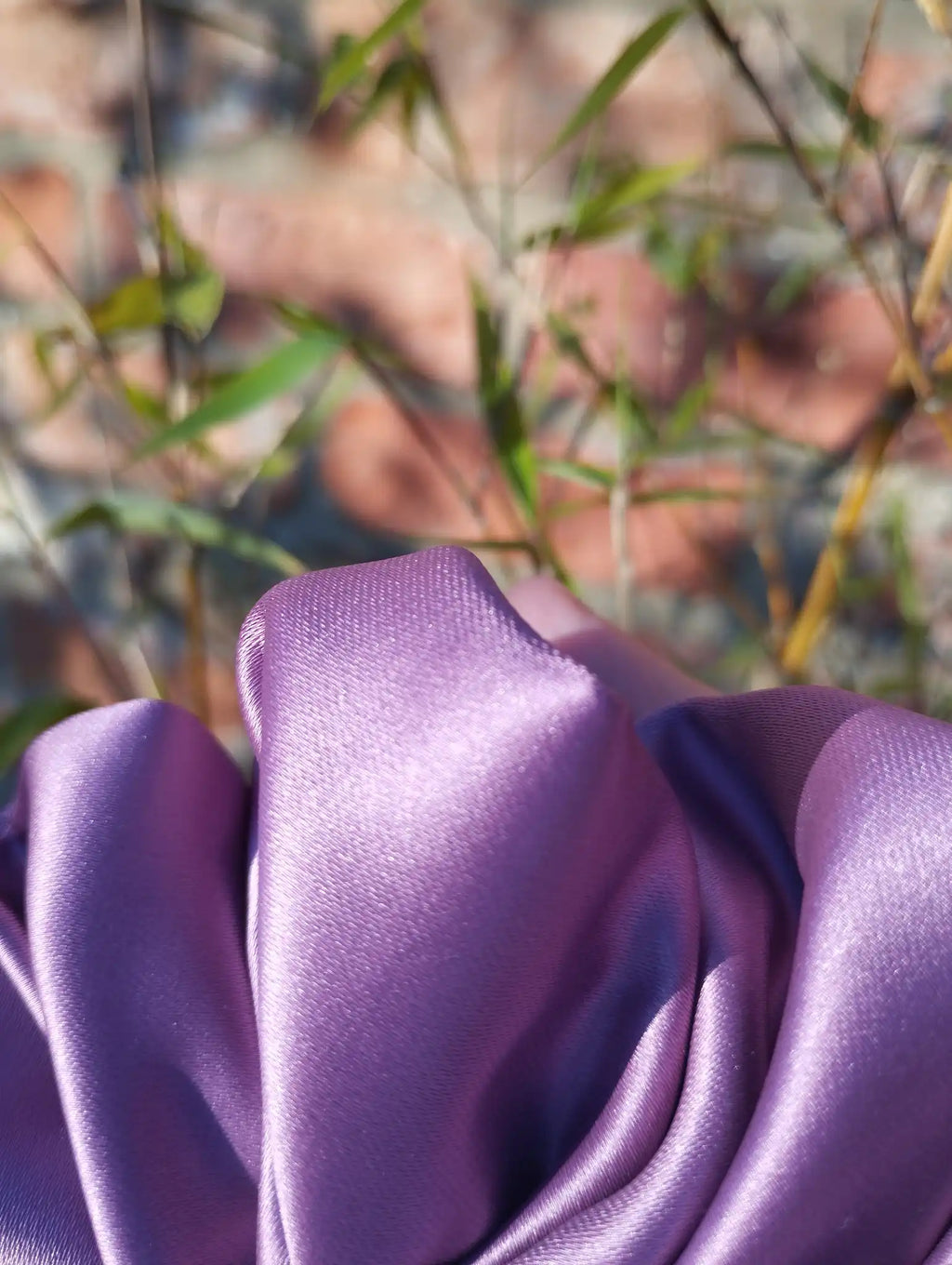 Close-up of the plum purple satin fabric and sheen on Wild Plum Jumbo scrunchie