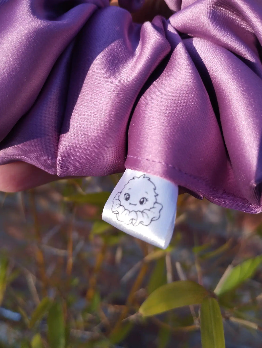 Scrunchlings character label and stitching on Wild Plum satin Jumbo scrunchie