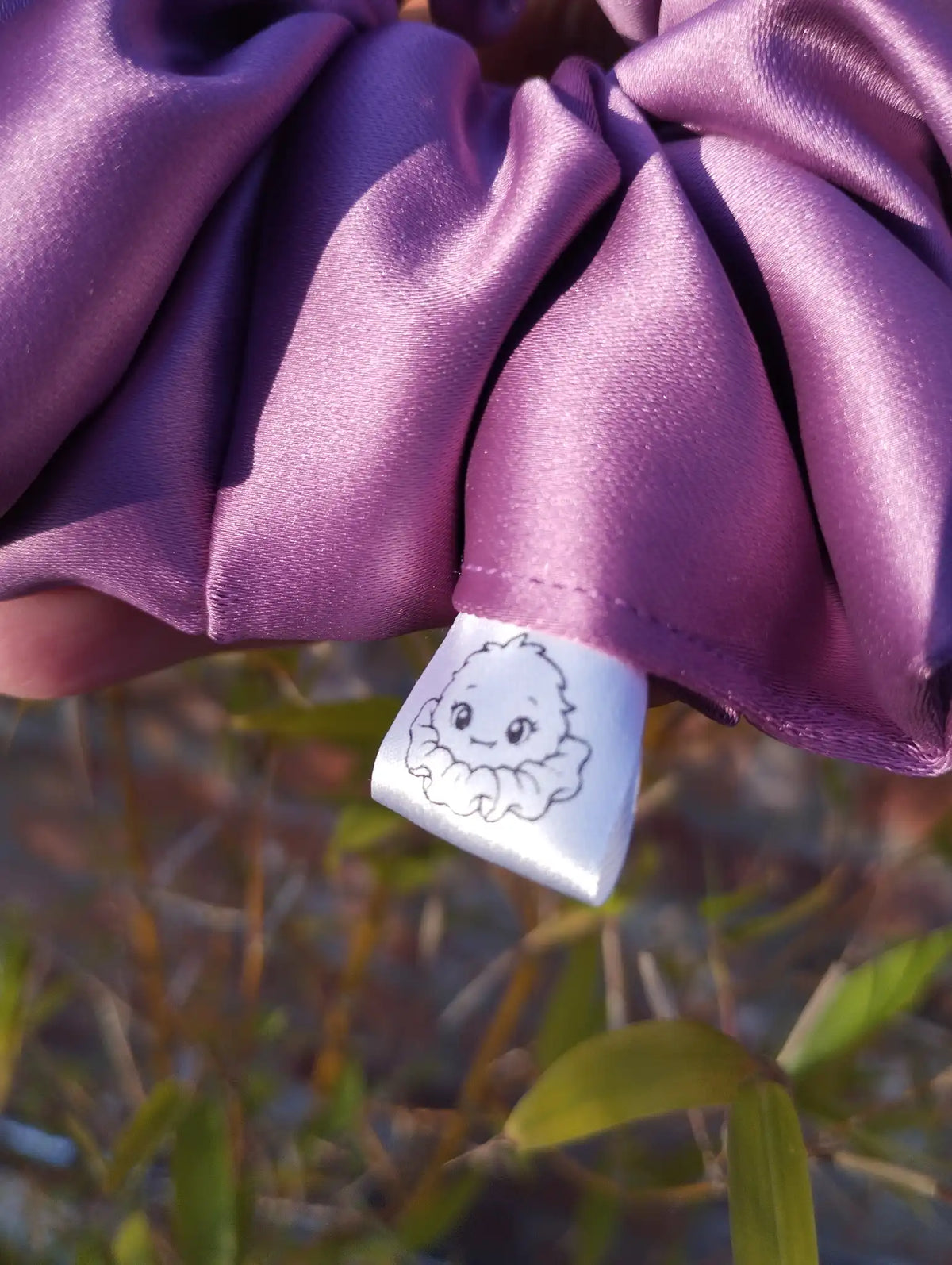 Scrunchlings character label and stitching on Wild Plum satin Jumbo scrunchie