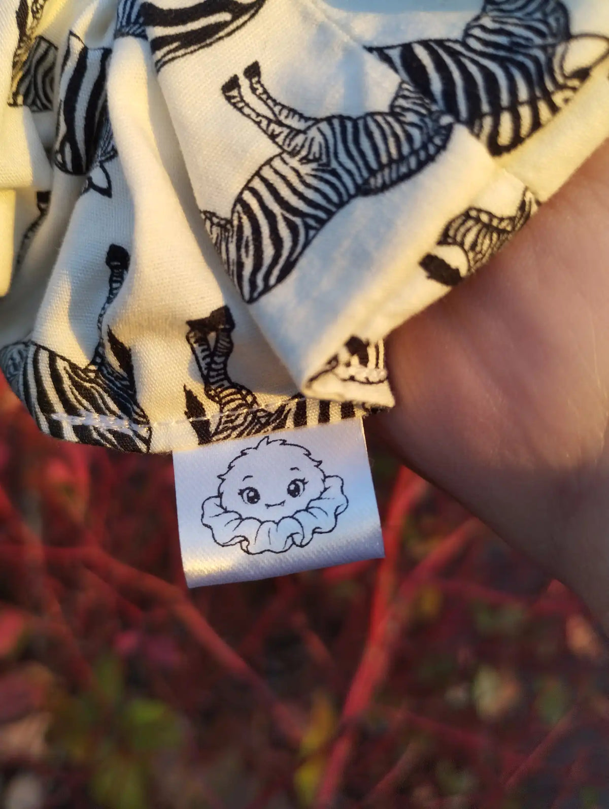 Scrunchlings character label and stitching on Zebra Parade Jumbo Scrunchie