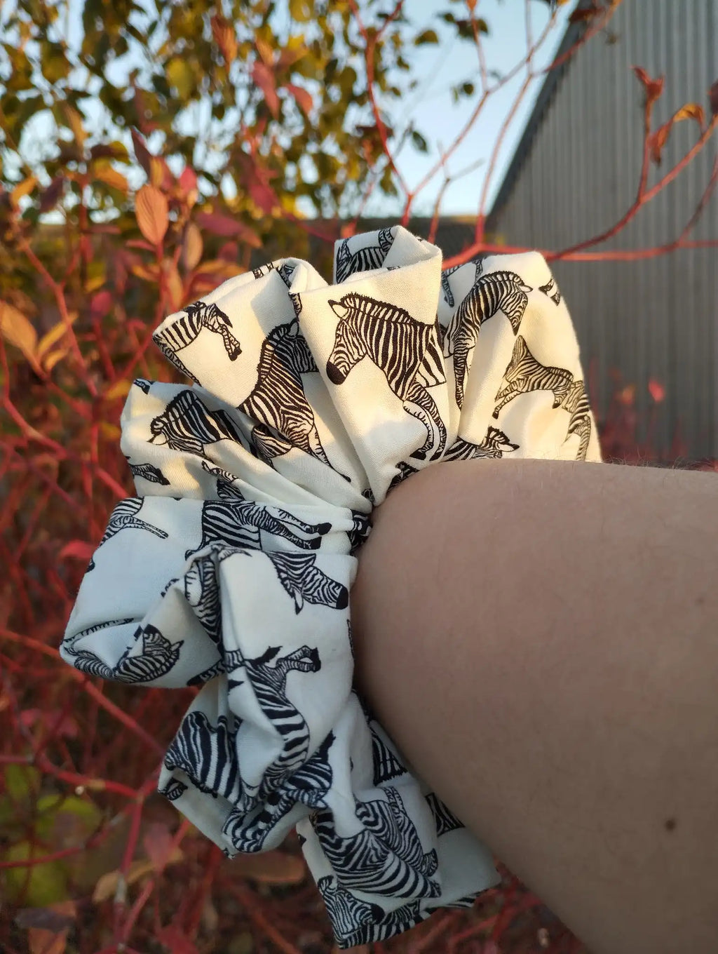 Zebra Parade Jumbo Scrunchie worn on a wrist to show its size